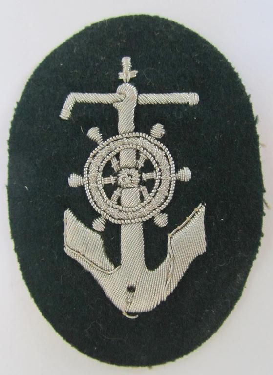 Neat, WH (Heeres) trade- and/or special-career insignia, being a detailed- and/or neatly hand-embroidered example as executed on darker-green-coloured wool, as was intended for a: 'Steuermann' (ie. enigineer-boat-pilot or helmsman)