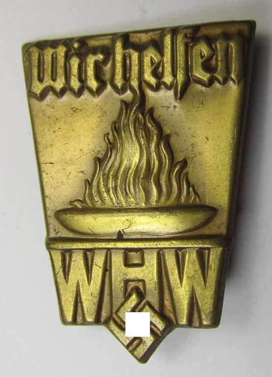 Golden-toned, W.H.W.- (ie. 'Winterhilfswerke'-) related day-badge (ie. 'tinnie') being a non-maker-marked example as was issued to commemorate a: 'WHW'-gathering ie. rally entitled: 'Wir Helfen'