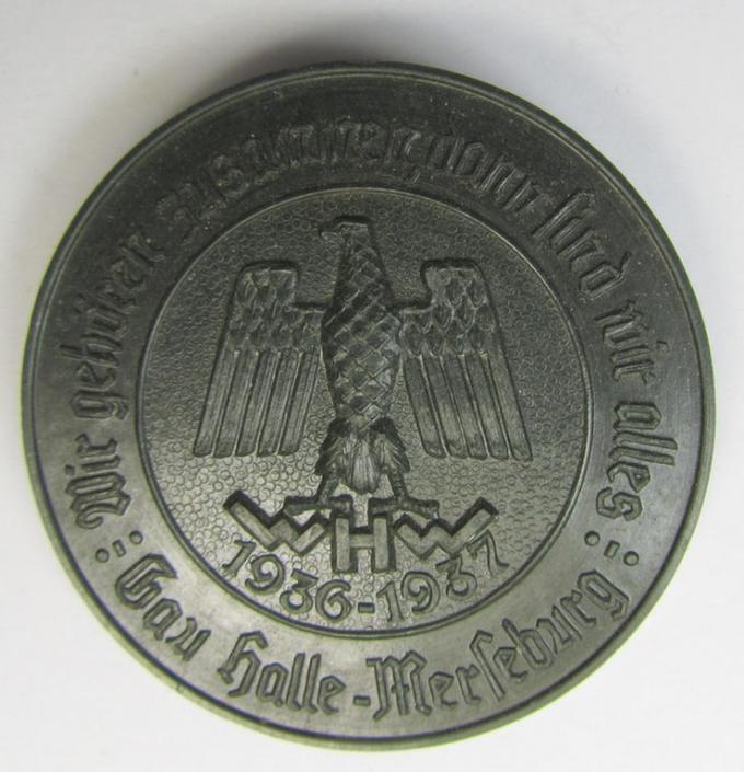 Resin-based- and darker-green-coloured, WHW- (ie. 'Winterhilfswerk'-) related day-badge (ie. 'tinnie' or: 'Veranstaltungsabzeichen') bearing the text: 'Wir gehören zusammen dann sind wir alles - Gau Halle-Merseburg - 1936-1937'