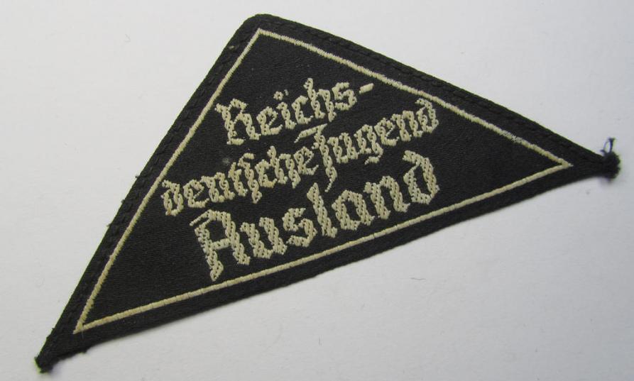 Superb - and extremely rarely encountered! - HJ/BDM (ie. 'Hitlerjugend' or: 'Bund Deutsche Mädel') district-triangle (ie. 'Gebietsdreieck') entitled: 'Reichs-deutsche Jugend Ausland' being a used specimen that misses its 'RzM'-etiket