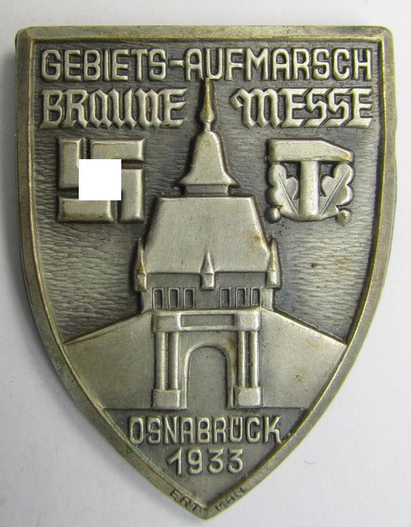 Early-period-, silverish-coloured- and/or tin-based, N.S.D.A.P.-related day-badge (ie. 'tinnie' or: 'Veranstaltungsabzeichen') being a commemorative example that is entitled: 'Gebiets-Aufmarsch - Braune Messe - Osnabrück - 1933'