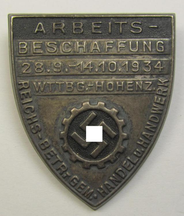 Silver-toned- (and/or tin-based) RAD- (ie. 'Reichsarbeitsdienst'-) related day-badge depicting a so-called: 'RAD-Zahnrad' and text: 'Arbeitsbeschaffung - 28.9.-14.10.1934 - Wttbg. Hohenz.' and sub-titled: 'Reichs-Betr. Gem. - Handel u. Handwerk'