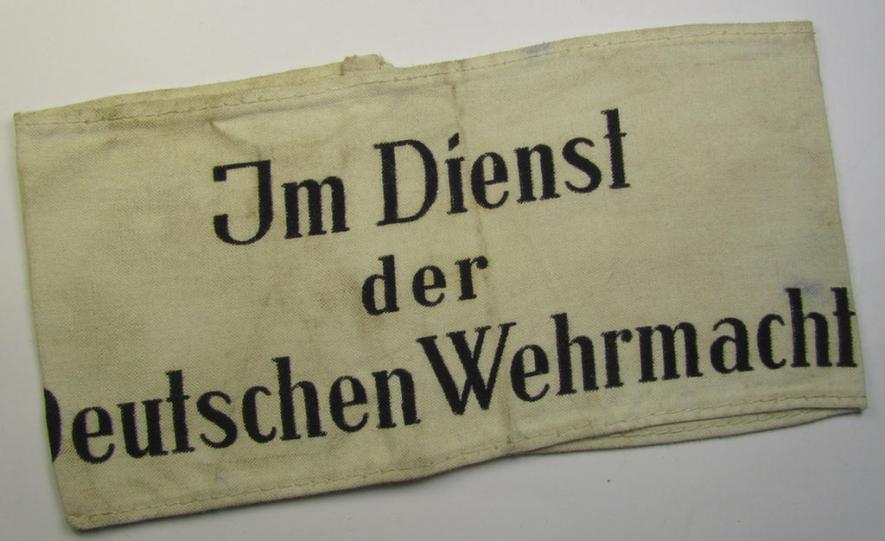 Linnen-based- and/or neatly 'printed', white-coloured armband (ie. 'Armbinde') entitled: 'Im Dienst der Deutschen Wehrmacht', as was intended for (civilian) staff-members of the German armed forces ie. 'Deutsche Wehrmacht'