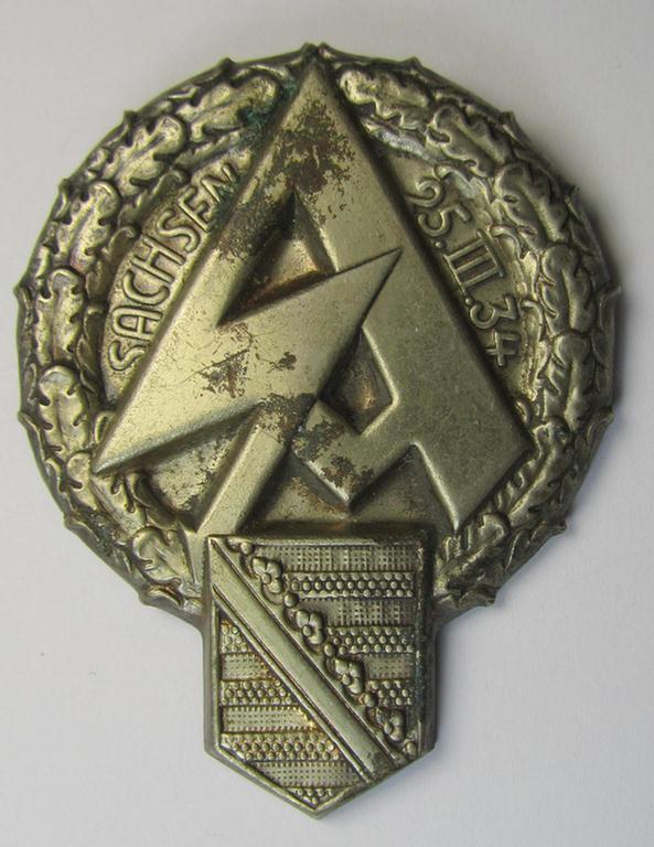 Commemorative, hollow-back- and/or silvered tin-based so-called: SA- (ie. 'Sturmabteilungen'-) related 'tinnie' being a non-maker-marked example showing a larger-sized SA-logo, provincial-shield and text: 'Sachsen - 25.III.34'