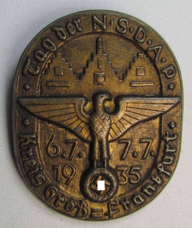 Commemorative, tin-based- and/or: golden-bronze-toned N.S.D.A.P.-related 'tinnie' showing a detailed eagle-device and towns'-scene with below that the text: 'Tag der N.S.D.A.P. - Kreis Gross-Frankfurt - 6.7/7.7. 1935'