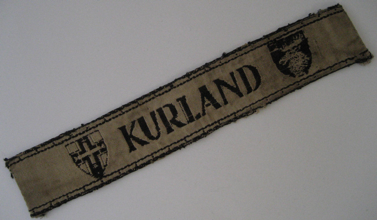  Cuff-title/armband: 'Kurland'