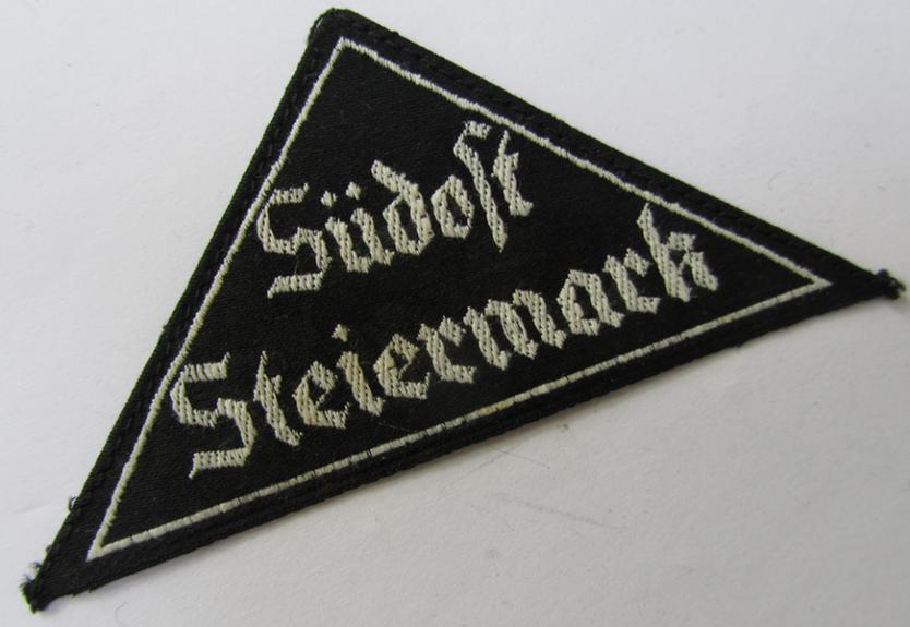 Attractive, 'HJ' ('Hitlerjugend') ie. 'BDM' ('Bund Deutscher Mädel'-) district-triangle (ie. 'Gebietsdreieck') entitled: 'Südost Steiermark' (being a 'virtually mint- ie. unissued' example that still retains its paper-based 'RzM'-etiket)