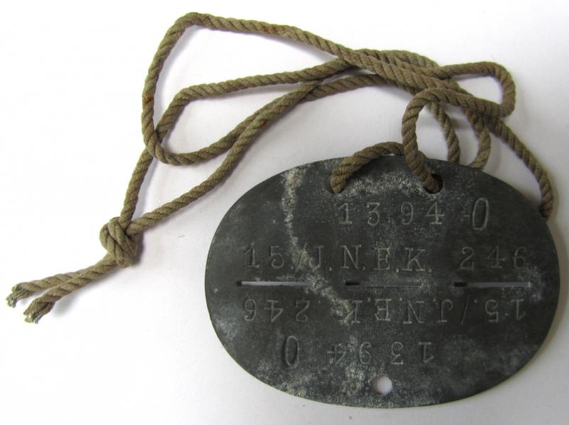 Neat, zinc-based, signals- or 'Nachrichten'- (ie. 'Infanterie'-) related ID-disc, bearing the stamped inscription ie. unit-signification: '15./J.N.E.K.246' and that comes on its original cord as issued - very nice, albeit clearly used ie. worn condition!