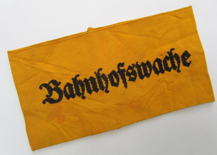 Very nice - and rarely encountered! - Wehrmacht-related, golden-yellow-coloured and/or linnen-based armband entitled: 'Bahnhofswache' (or railway-station guard), in overall very nice (ie. moderately used-) condition