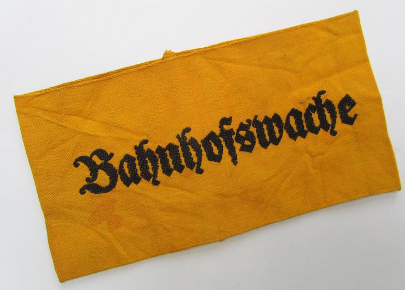 Very nice - and scarely encountered! - Wehrmacht-related, golden-yellow-coloured and/or typical linnen-based armband (ie. 'Armbinde') as executed in 'BeVo'-weave-pattern entitled: 'Bahnhofswache'