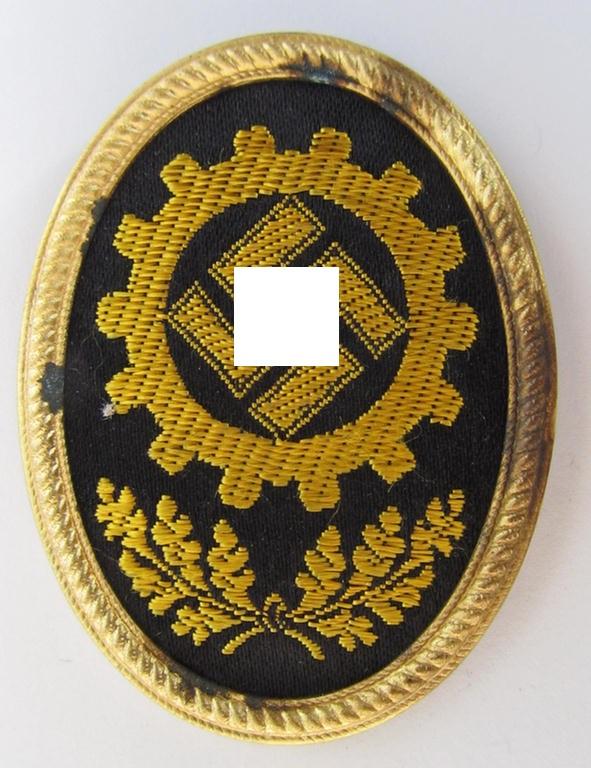 Neat, golden-toned- and/or partly machine-embroidered- (ie. 'BeVo'-woven-) 'DAF' (ie. 'Deutsche Arbeitsfront') cap-badge, being a detailed example that is nicely maker-marked: 'RzM' and/or: 'Lieferant 47' on its back