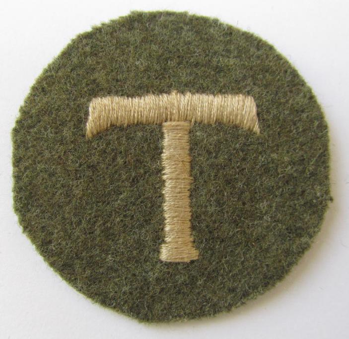 Interesting - and with certainty rarely encountered! - (IMO) OT- (ie. 'Organisation Todt'-) related, machine-embroidered-, trade- ie. special-career-patch as was executed in greenish-brown-coloured wool and depicting a 'T'-character