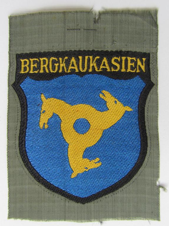 Attractive, 'BeVo'-type armshield (of the second pattern-) entitled: 'Bergkaukasien', being a piece as intended for a volunteer who served within the 'Deutsche Wehrmacht' ie. within the 'Berg- o. Nord-Kaukasisches Legion'