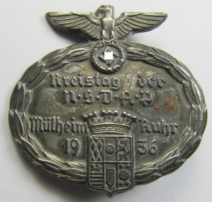 Commemorative, silver-toned-, 'N.S.D.A.P.'-related 'tinnie', being a non-maker-marked- and fairly high-quality example, depicting an N.S.D.A.P.-party-eagle and town-shield with in its center the text: 'Kreistag der N.S.D.A.P. - Mühlheim Ruhr 1936'
