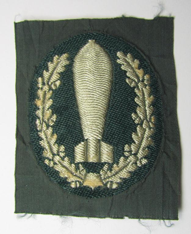 Superb - and extremely rarely encountered! - 'BeVo'-woven version of a WH (Heeres) so-called: trade- and/or special-career insignia, as was intended for a: 'Nebelwerfer Richtkannonier' (or: qualified smoke-troops canon-operator)