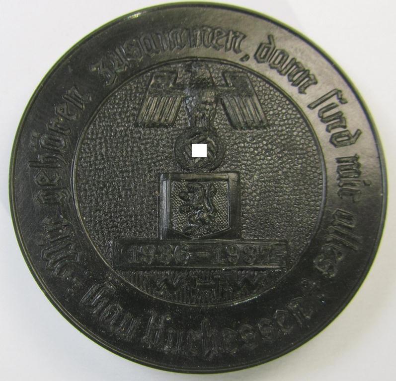 Resin-based- and black-coloured, WHW- (ie. 'Winterhilfswerk'-) related day-badge (ie. 'tinnie' or: 'Veranstaltungsabzeichen') bearing the text: 'Wir gehören zusammen dann sind wir alles - Gau Kurhessen - 1936-1937'