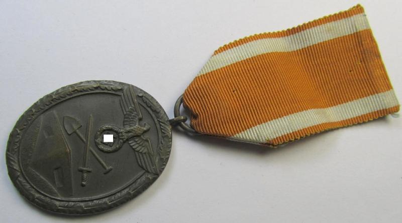 Medal-set: 'Deutsches Schutzwall Ehrenzeichen' (aka: 'Westwall'-medal) being a non-maker-marked- and/or: 'Buntmetall'-based specimen that comes mounted onto its period- (and neatly folded ie. pre-confectioned) ribbon (ie. 'Bandabschnitt')
