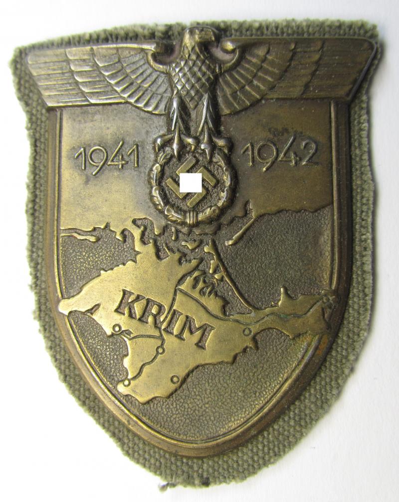 Attractive, WH (Heeres o. Waffen-SS) 'Krim'-campaign-shield that comes mounted onto its replaced, field-grey-coloured 'backing' and that comes in an issued-, minimally worn and/or carefully tunic-removed-, condition