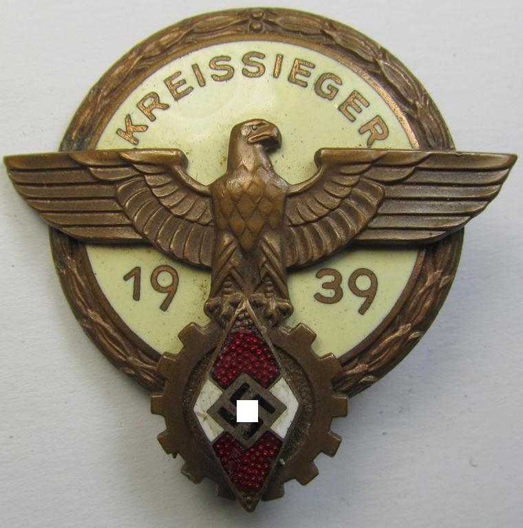 Moderately worn 'HJ'- ('Hitlerjugend') ie. 'BDM'- ('Bund Deutscher Mädel') related: 'Reichsberufswettkampf-Siegerabzeichen' (of the 2nd model) entitled: 'Kreissieger 1939' and being a neatly maker- (ie.: 'Hermann Aurich'-) marked example