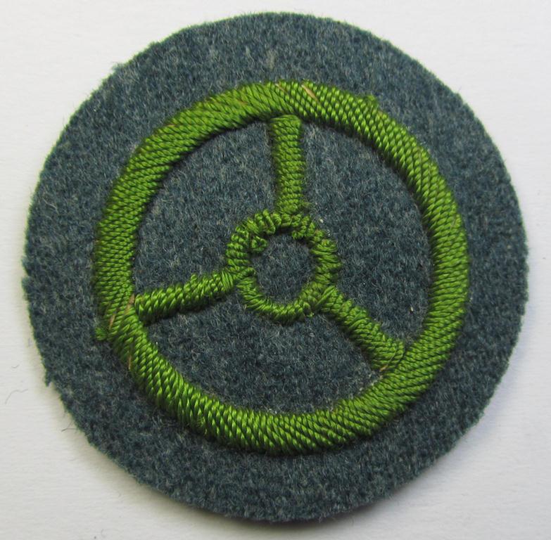 Police- (ie. 'Schutzpolizei'-) related, neatly hand-embroidered, trade- ie. special-career patch (ie. 'Laufbahn- o. Tätigkeitsabzeichen') depicting a bright-green-coloured steering-wheel as was intended for: 'Kraftfahrpersonal'