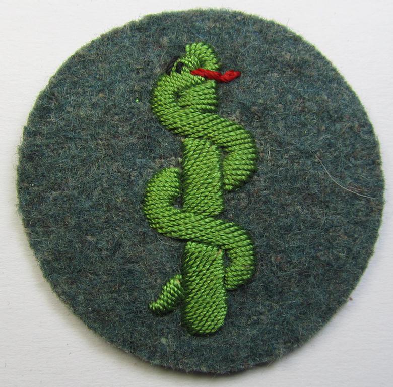 Police- (ie. 'Schutzpolizei'-) related, neatly hand-embroidered, trade- ie. special-career patch (ie. 'Laufbahn- o. Tätigkeitsabzeichen') depicting a bright-green-coloured 'Aesculapus'-symbol as was intended for: 'Sanitäter'