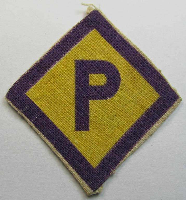 Printed-version of a so-called: Polish forced-labour-breast-patch (ie. 'Brustabzeichen für Poln. Zwangsarbeiter o. Fremdarbeiter') being a moderately used example that comes in a nicely confectioned ie. pre-folded condition