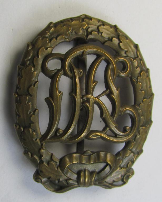 Neat - and just minimally worn- ie. used! - example of a: 'Reichssportabzeichen DRL in Bronze' (or: DRL sports'-badge in bronze) being an example that is unusually void of a makers'- and/or: 'DRGM'-designation