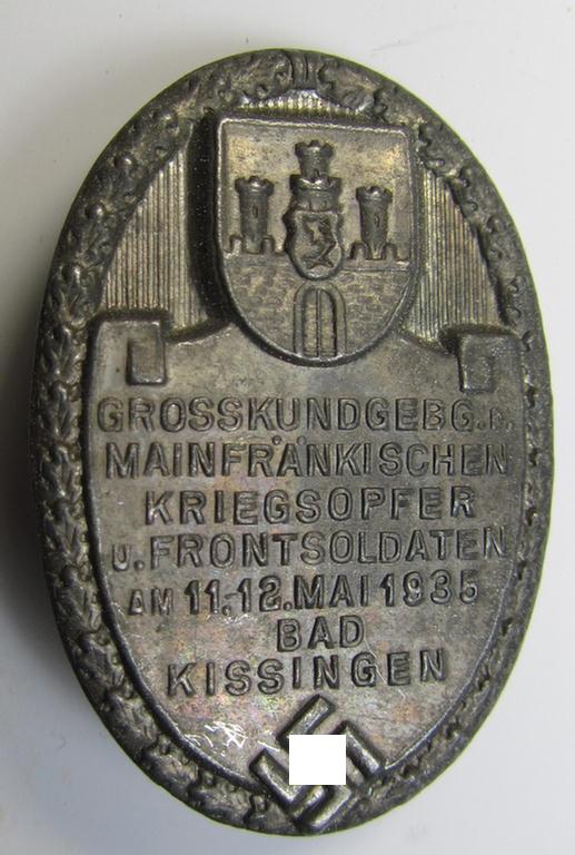 Silverish-grey-toned, N.S.K.O.V.-related day-badge (ie. 'tinnie') as was issued to commemorate a gathering entitled: 'Grosskundgebung der Mainfränkischen Kriegsopfer u. Frontsoldaten am 11.12. Mai 1935 - Bad Kissingen'