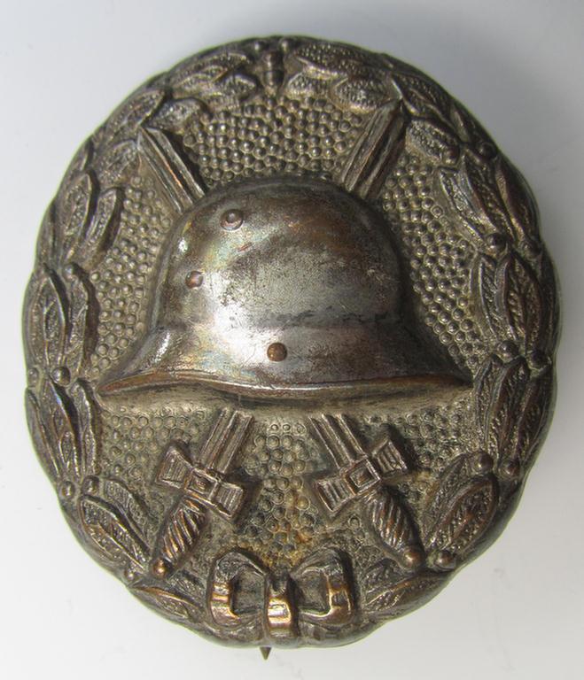 Attractive, WWI-pattern, silver-class wound-badge (ie.: 'Verwundeten Abzeichen in Silber') being a detailed (and magnetic) example as executed in silvered 'Buntmetall' and that comes in a moderately used- ie. most certainly worn, condition