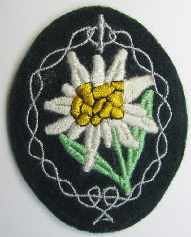 Attractive, WH (Heeres) enlisted-mens'- (ie. NCO-) type, so-called: 'Edelweiss'-armpatch, being a machine-embroidered example as was executed on darker-green wool as was intended for usage by the: 'Gebirgsjäger-Truppen' throughout the war