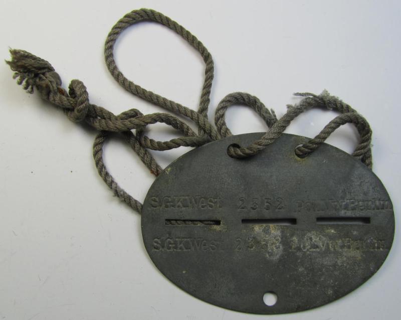 Attractive, zinc-based police- (ie. 'Polizei'-) related ID-disc bearing the clearly stamped unit-designation that simply reads: 'S.GK.West - Pol.VW. Berlin' and that comes mounted onto its period cord as issued- and/or worn
