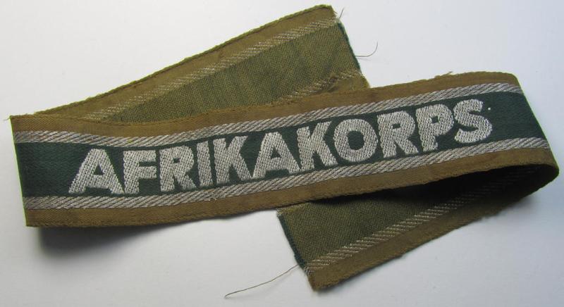 Attractive, 'BeVo'-like cuff-title (ie. 'Ärmelstreifen') entitled: 'Afrikakorps' being a with certainty issued and truly worn example that comes in an overall nice- (ie. minimally shortened- and once tunic-attached-), condition