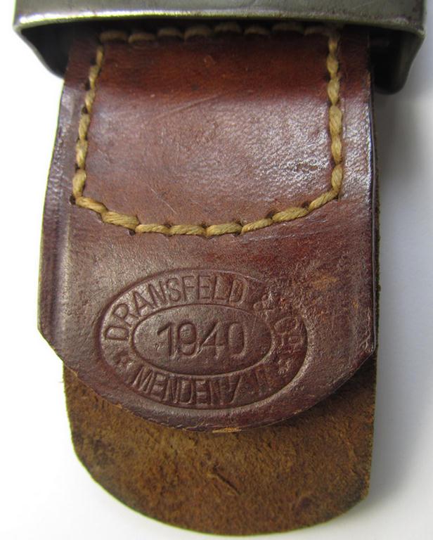 WH (Heeres) field-grey-coloured- and/or steel-based belt-buckle being a maker- (ie. 'Dransfeld & Co.'-) marked- and/or: '1940'-dated example that comes mounted onto its leather-based tab and that comes in a moderately used- ie. worn, condition