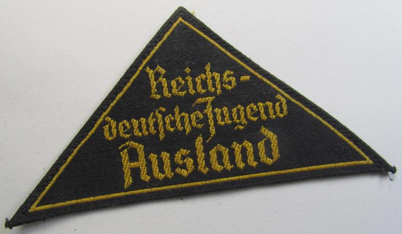 Superb - and extremely rarely encountered! - 'HJ' ('Hitlerjugend') district-triangle (ie. 'Gebietsdreieck') entitled: 'Reichs-deutsche Jugend Ausland' being an (I deem) worn- ie. used specimen that misses its 'RzM'-etiket