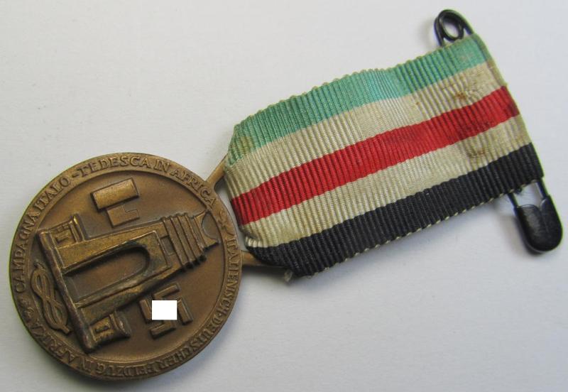 Superb, golden-bronze-coloured- (and I deem 'Buntmetall'-based-) example of a: 'Deutsch-Italienische Feldzugsmedaille' (or: German-Italian campaign medal) that comes mounted onto its (regular-sized) piece of original ribbon