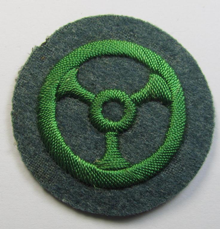 Police- (ie. 'Schutzpolizei'-) related, neatly hand-embroidered trade- ie. special-career patch (ie. 'Laufbahn- o. Tätigkeitsabzeichen') depicting a bright-green-coloured steering-wheel as was intended for: 'Kraftfahrpersonal'