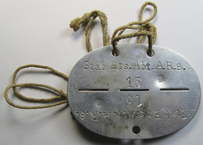 Attractive, aluminium-based, WH (Heeres) related ID-disc bearing the clearly stamped unit-designation that reads: 'Stab Ers.Abt.A.R.8' and that comes still mounted onto its (period-attached) cord as issued- and/or worn