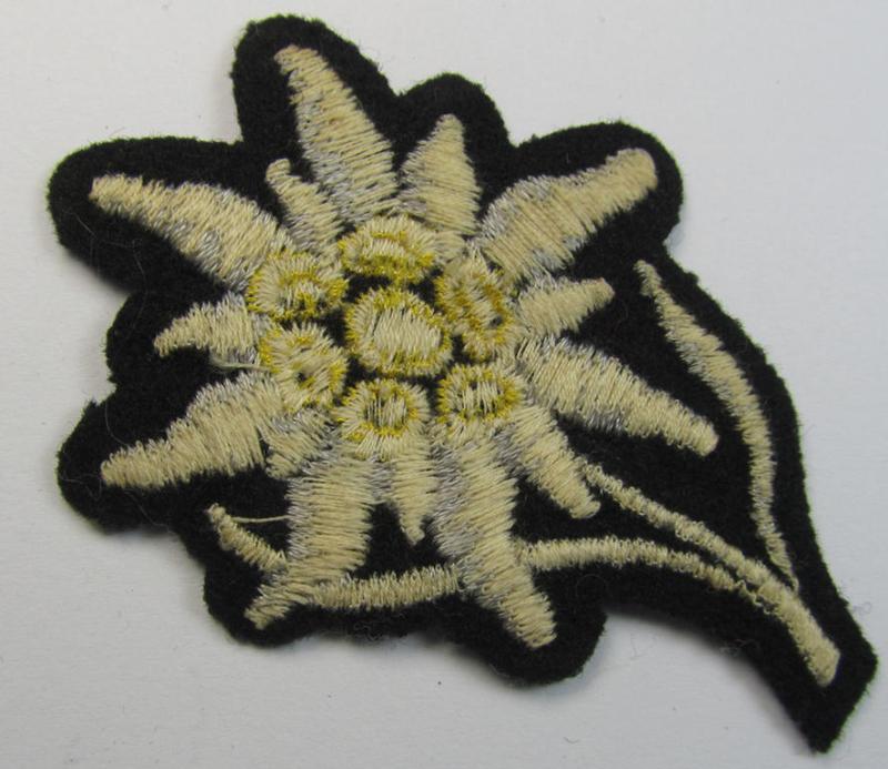 Attractive, Waffen-SS-pattern black-coloured M43-cap-insignia (ie. 'Mützenabzeichen') depicting an: 'Edelweiss'-flower as was specifically used by the various 'Gebirgsjäger'- (ie. mountain-troops-) related divisional-staff