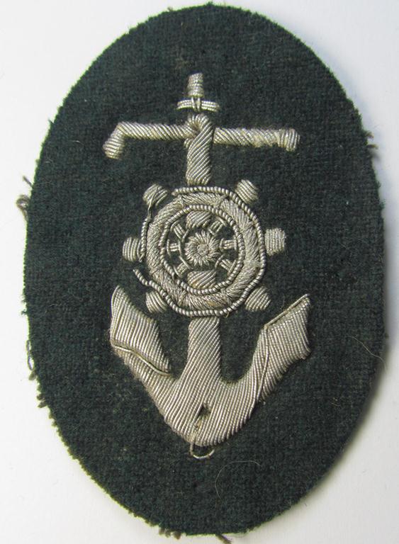 Superb, WH (Heeres) trade- and/or special-career insignia, being a detailed- and/or neatly hand-embroidered example as executed on darker-green-coloured wool, as was intended for a: 'Steuermann' (ie. enigineer-boat-pilot or helmsman)