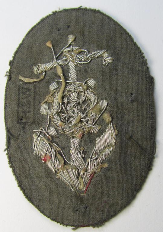Superb, WH (Heeres) trade- and/or special-career insignia, being a detailed- and/or neatly hand-embroidered example as executed on darker-green-coloured wool, as was intended for a: 'Steuermann' (ie. enigineer-boat-pilot or helmsman)