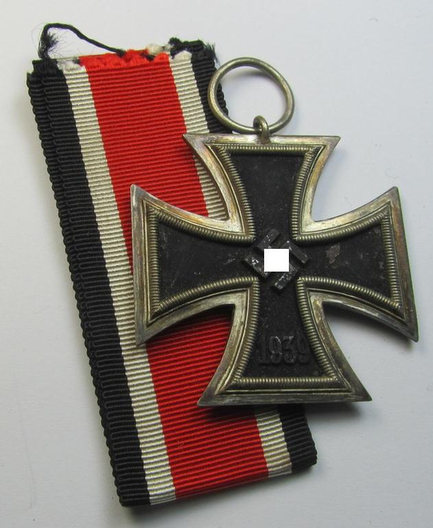 'Eisernes Kreuz II. Klasse' being a maker- (ie. '25'-) marked example that comes with its original- and never-mounted ribbon (ie. 'Bandabschnitt') as was produced by the maker (ie. 'Hersteller'): 'AG der Graveur-, Gold-…etc.'