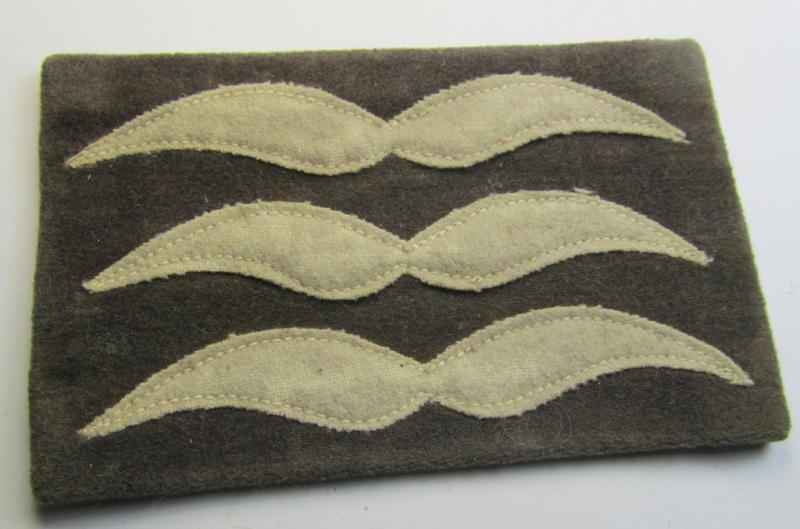 Single - but nevertheless scarcely found! - WH (LW) light-blue-coloured- and/or woolen-based, NCO-type rank-patch (aka 'moustache') as was specifically intended for usage by a non-commissioned officer holding the rank of: 'Feldwebel' (ie. sergeant)