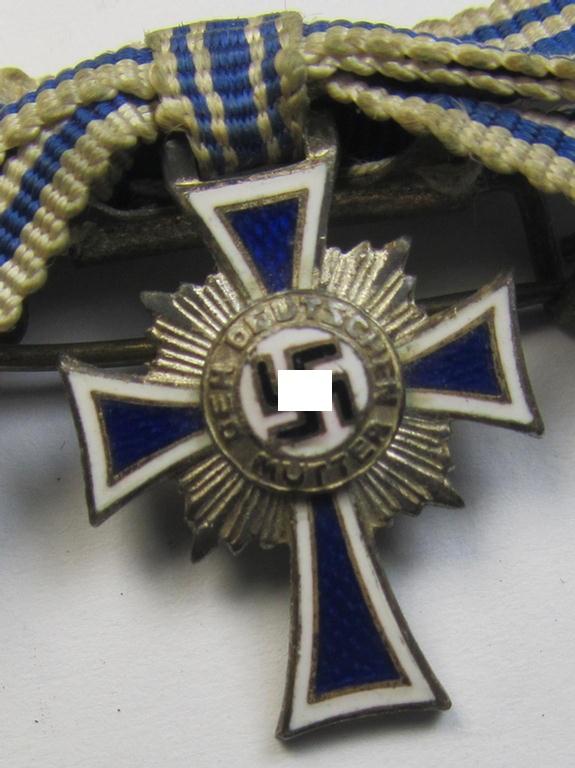 Miniature of an: 'Ehrenkreuz der deutschen Mutter - zweite Stufe' (or: silver-class mothers'-cross) being a maker- (ie. 'L/16'-) marked example that comes in an overall nice- (albeit moderately worn- ie. used-), condition