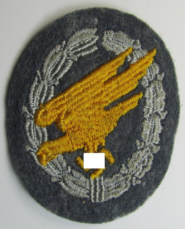 Attractive, WH (Luftwaffe) 'Fallschirmschützen-Abzeichen in Stoff' (or: cloth-based paratroopers'-jump-badge) being a nicely machine-embroidered specimen that comes in a probably issued albeit never used- ie. 'virtually mint', condition