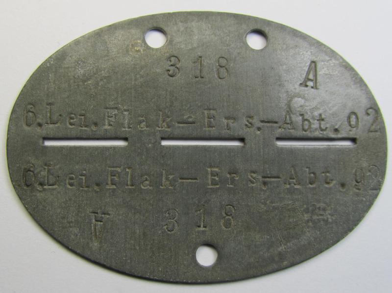 Attractive, typical zinc-based, WH (Luftwaffe) ie. 'LW-Flak-Artillerie'-related ID-disc (ie. 'Erkennungsmarke') bearing the stamped unit-designation that simply reads: '6. Lei.Flak-Ers.-Abt. 92'