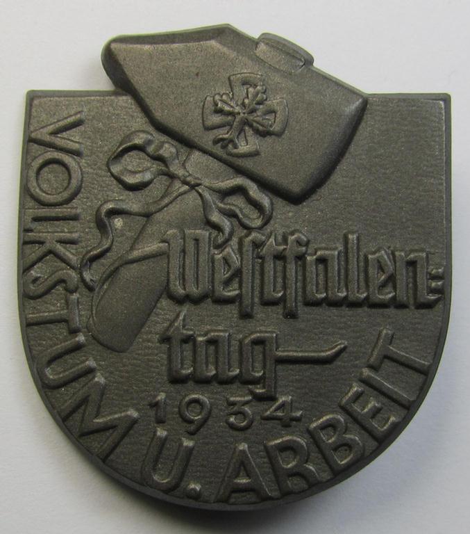 Silverish-grey-toned, tin-based so-called: 'DAF'-related 'tinnie' being a non-maker-marked example depicting a stylised hammer and rounded-swastika coupled with the text: 'Westfalentag - Volkstum u. Arbeit - 1934'