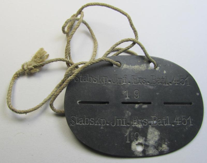Zinc-based, WH (Heeres) 'Infanterie'- (ie. infantry-) related ID-disc, bearing the clearly stamped unit-designation that simply reads: 'Stabskp. Inf.Ers.Batl. 451' and that comes mounted on its period cord