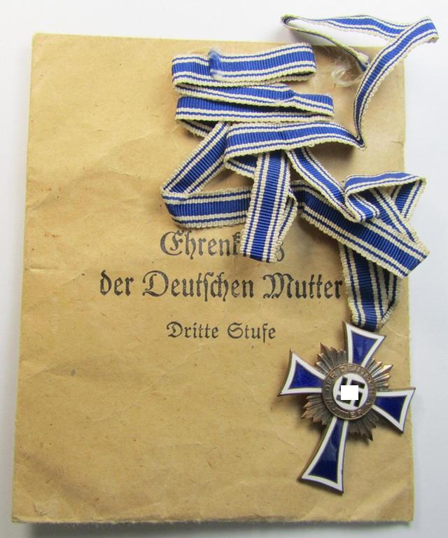 Attractive, 'Ehrenkreuz der deutschen Mutter - dritte Stufe' (or: bronze-class mothers'-cross) that came mounted onto its long-sized ribbon and that came stored in its period pouch (by the maker: 'Jakob Bengel - Idar-Oberstein')
