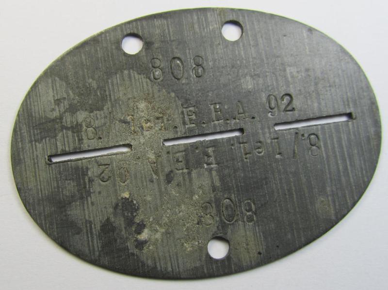 Zinc-based, WH (Luftwaffe) ie. 'LW-Flak-Artillerie'-related ID-disc (ie. 'Erkennungsmarke') bearing the stamped unit-designation that simply reads: '8./Lei.F.E.A. 92' and that comes as issued- and/or worn