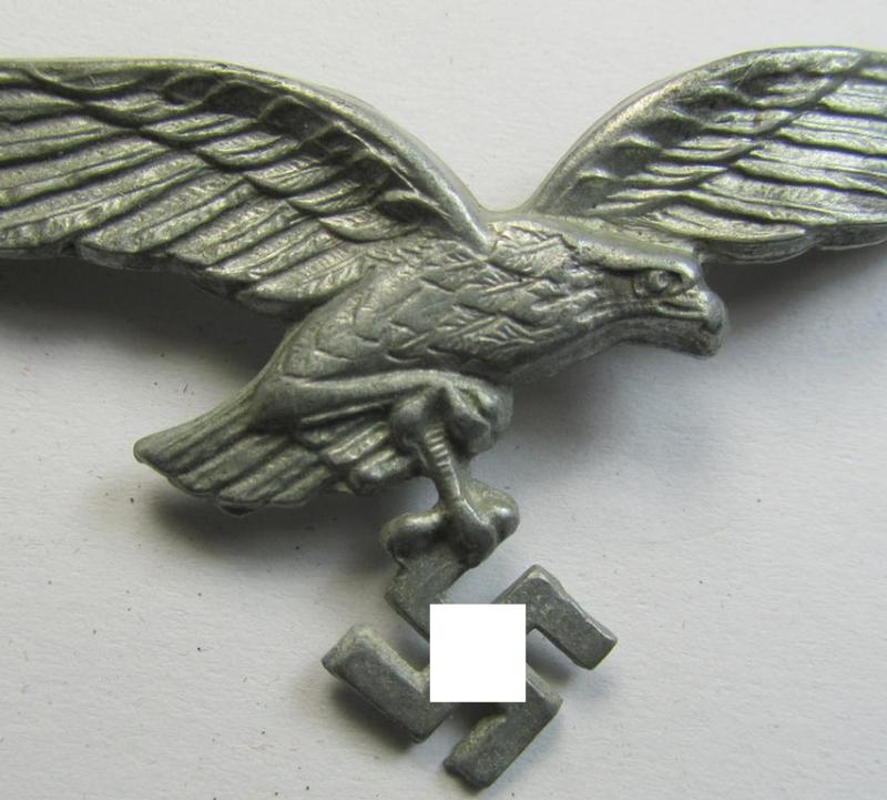 Neat - and I deem never used- nor cap-attached - greyish-silver-toned- and/or typical zinc- (ie. 'Feinzink'-) based, WH (Luftwaffe) visor- (ie. 'Schirmmützen'-) cap-eagle (being a maker- (ie. 'A'-) marked example of the regular second-type pattern)